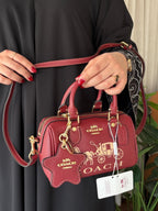 Coach Bag | Mini Rowan Crossbody Bag (featuring a prominent horse & carriage motif and matching star logo charm) – Crimson Red – Cherry (Pebbled leather with gold-tone hardware)